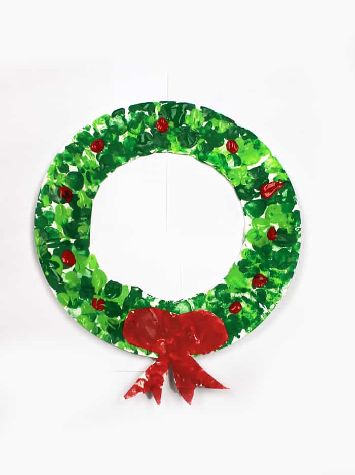 Make this easy paper plate wreath craft for kids using paint, scissors, and a paper plate.