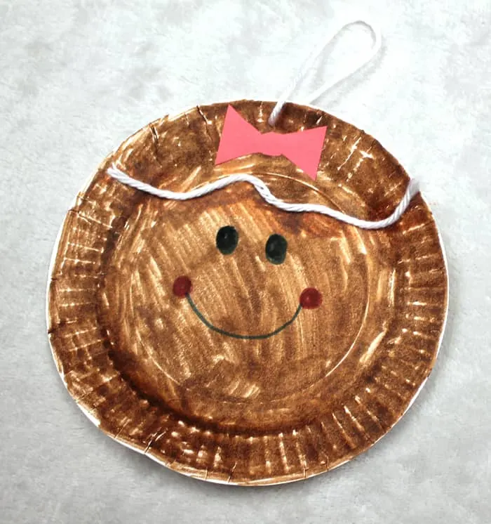 Make this cute gingerbread Christmas ornament. This easy craft for kids is made using a paper plate and markers.