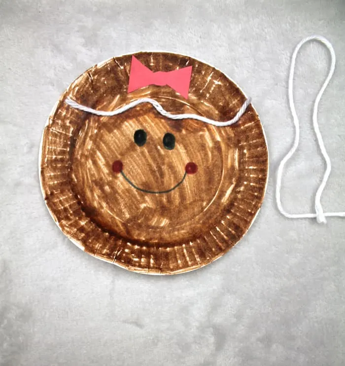 Make this cute gingerbread Christmas ornament. This easy craft for kids is made using a paper plate and markers.